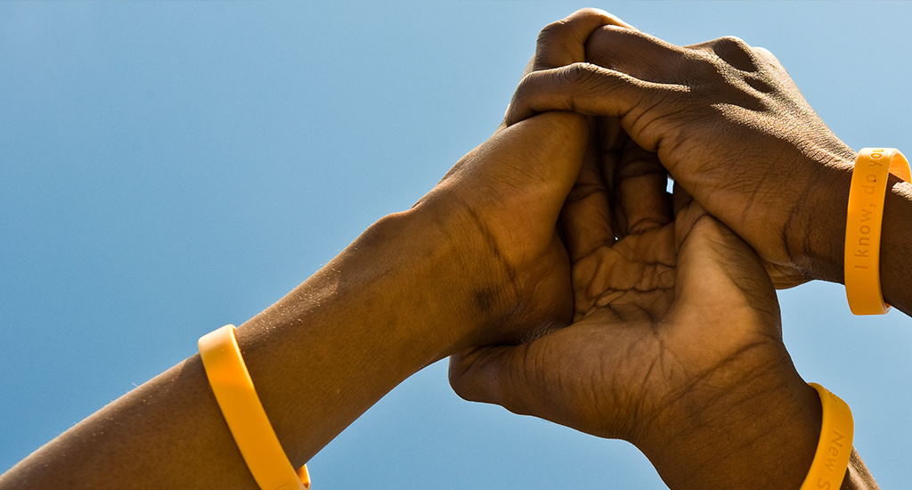 Three men joining hands.